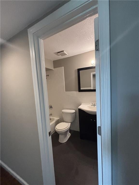 full bath featuring a textured ceiling, visible vents, shower / bathtub combination, toilet, and vanity