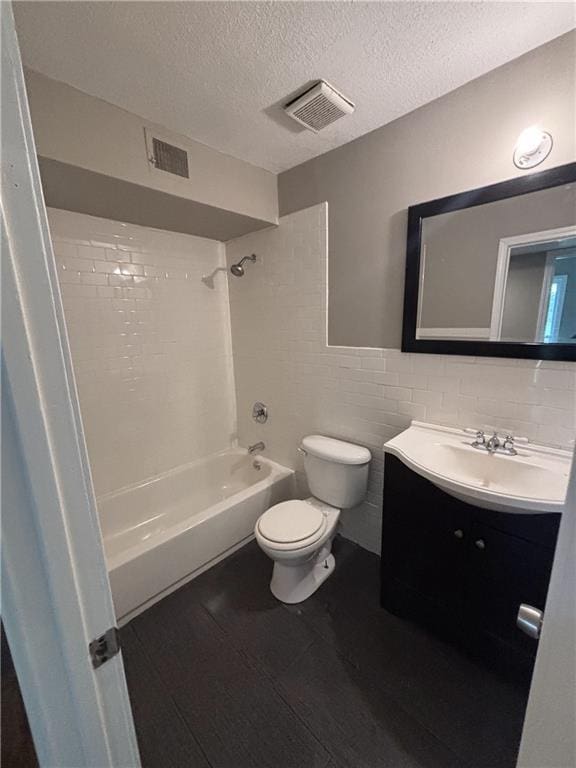bathroom with toilet, visible vents, wood finished floors, and  shower combination