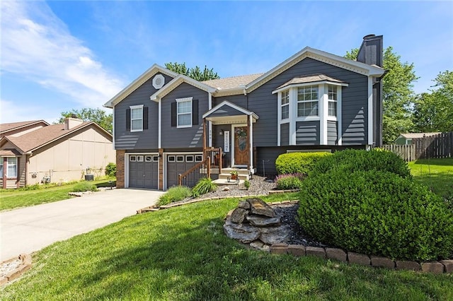 split foyer home with driveway, a chimney, and a garage