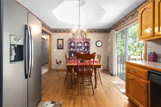 dining room with light wood-style flooring, a chandelier, and a skylight