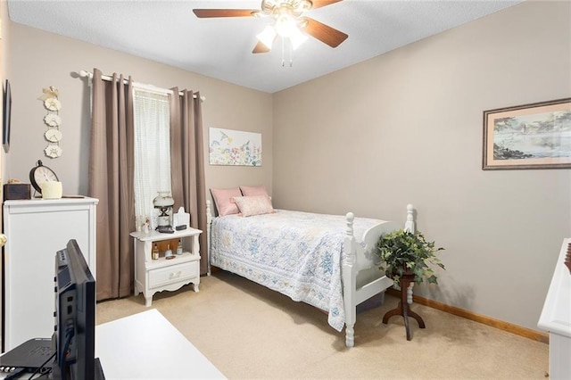 bedroom featuring light colored carpet, a ceiling fan, and baseboards
