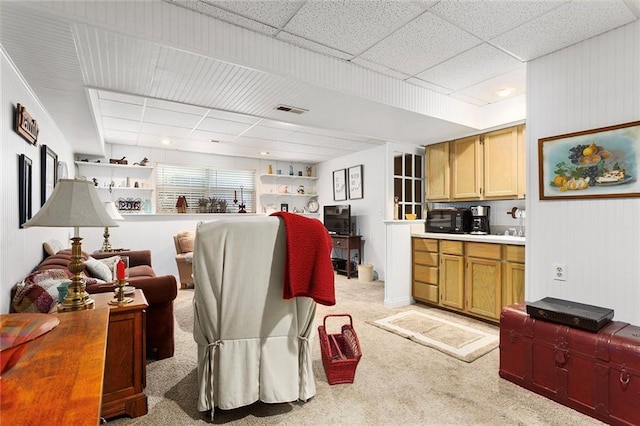 living room with light colored carpet and a paneled ceiling
