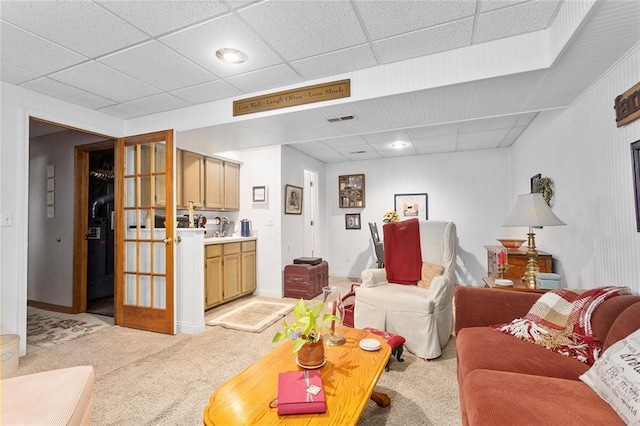 living area with light carpet and a drop ceiling