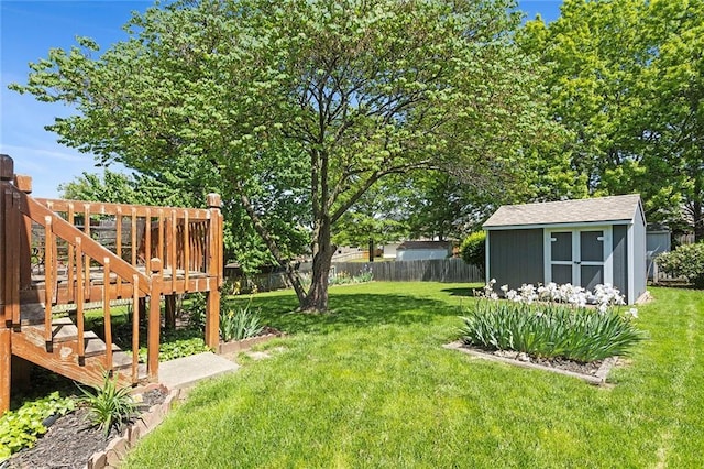view of yard featuring a storage unit, an outbuilding, and a wooden deck