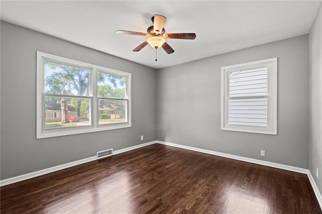 unfurnished room with ceiling fan, dark wood-style flooring, and baseboards