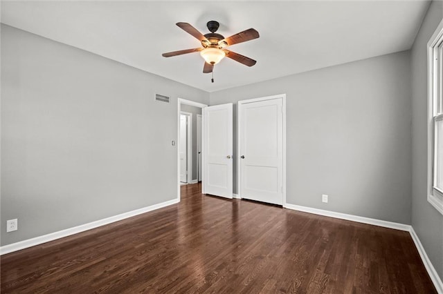 unfurnished bedroom featuring baseboards, wood finished floors, ceiling fan, and a closet
