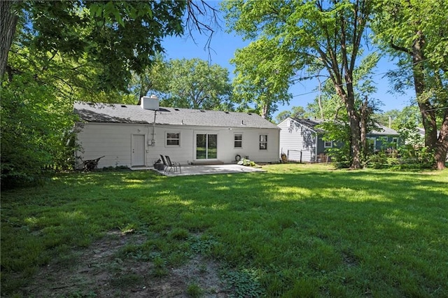 rear view of house with a patio and a yard