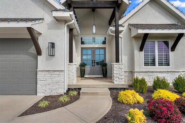 entrance to property featuring french doors, stone siding, and stucco siding