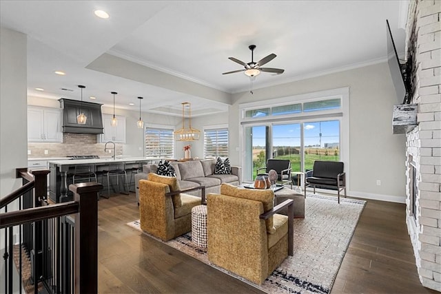 living area with crown molding, baseboards, ceiling fan, and dark wood-style floors