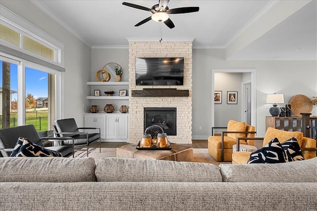 living room with ceiling fan, a fireplace, ornamental molding, and wood finished floors