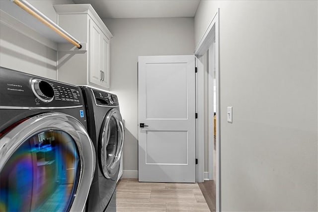 washroom featuring independent washer and dryer, wood finish floors, baseboards, and cabinet space