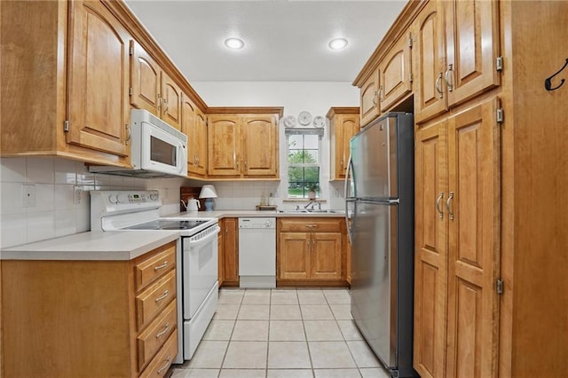 2111 N 83rd Pl, Kansas City, KS 66109 - kitchen featuring white appliances, tasteful backsplash, brown cabinetry, light countertops, and recessed lighting