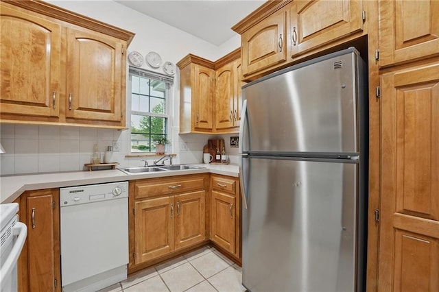2111 N 83rd Pl, Kansas City, KS 66109 - kitchen with freestanding refrigerator, white dishwasher, stove, tasteful backsplash, and light tile patterned floors