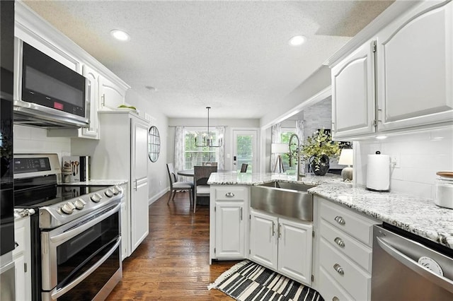 1125 SW Hillcrest Dr, Blue Springs, MO 64015 - kitchen featuring stainless steel appliances, a textured ceiling, white cabinets, dark wood-type flooring, and a peninsula