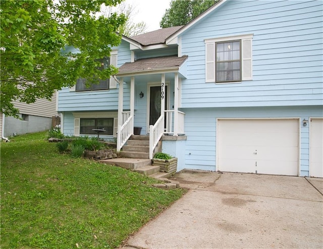 split foyer home featuring concrete driveway, a front yard, and a garage