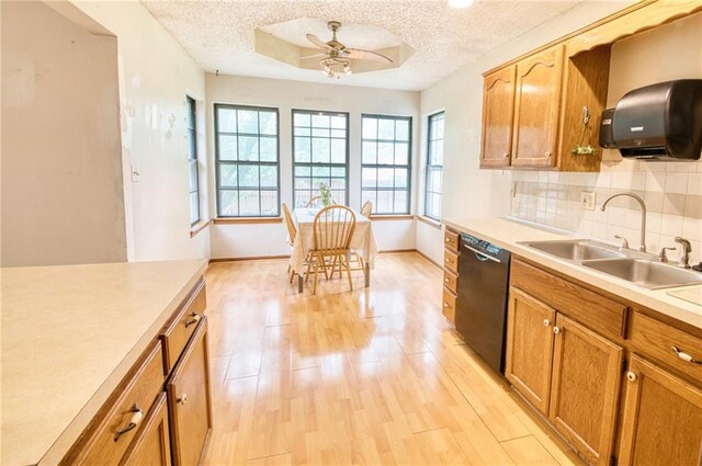 kitchen featuring a sink, light countertops, a textured ceiling, and dishwasher