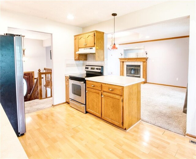 kitchen with light wood-style floors, light countertops, under cabinet range hood, and stainless steel appliances