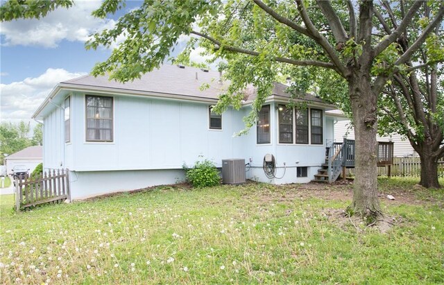 back of house featuring fence, stairs, central AC unit, crawl space, and a lawn