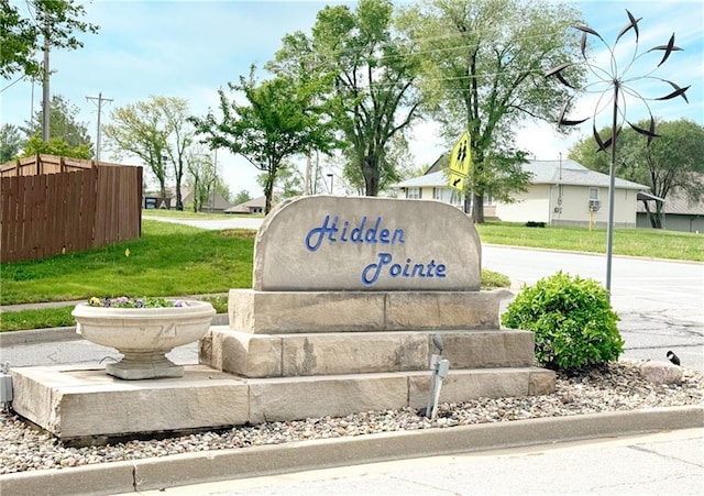 community / neighborhood sign featuring fence