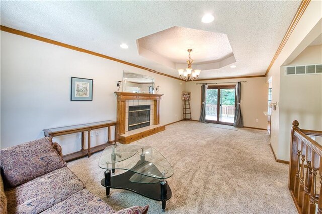 2109 NW Hidden Pointe Ct, Blue Springs, MO 64015 - carpeted living room featuring a tray ceiling, a textured ceiling, ornamental molding, a tile fireplace, and a chandelier