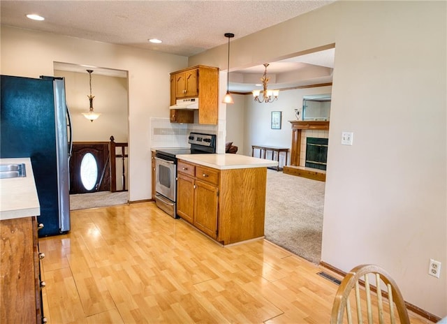 2109 NW Hidden Pointe Ct, Blue Springs, MO 64015 - kitchen with appliances with stainless steel finishes, under cabinet range hood, brown cabinetry, light countertops, and recessed lighting