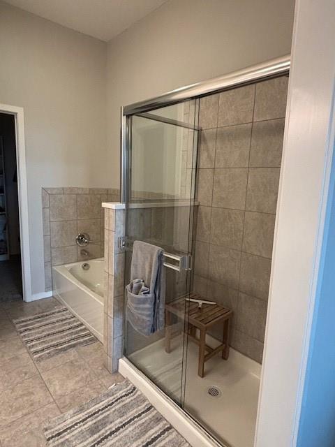 full bathroom featuring a shower stall and a bath