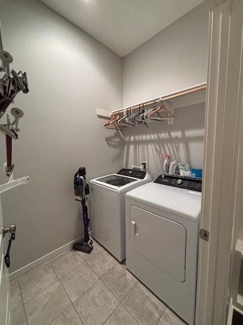 washroom with baseboards, laundry area, light tile patterned flooring, and independent washer and dryer