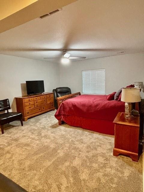 bedroom with carpet flooring, a ceiling fan, and visible vents