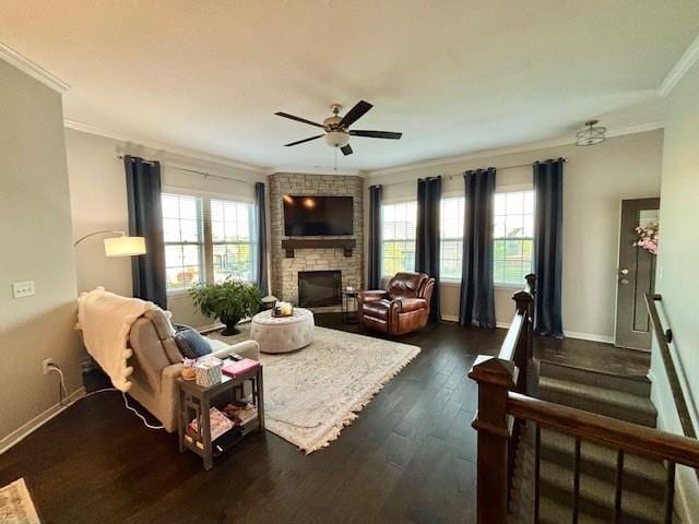 living area with a ceiling fan, a stone fireplace, ornamental molding, and plenty of natural light