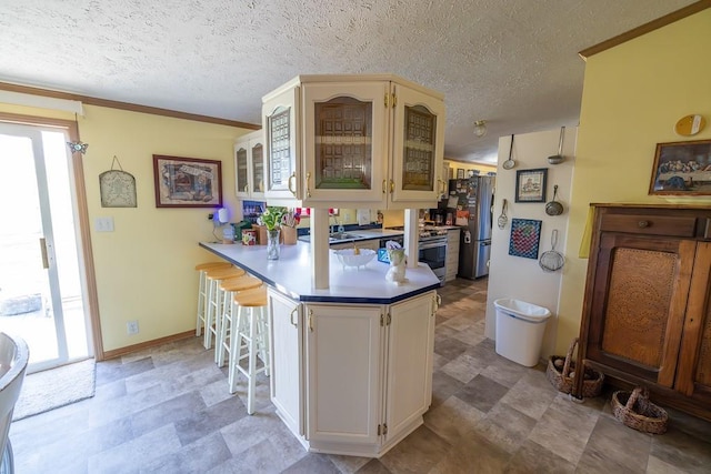 kitchen with glass insert cabinets, stainless steel appliances, baseboards, a peninsula, and a kitchen breakfast bar