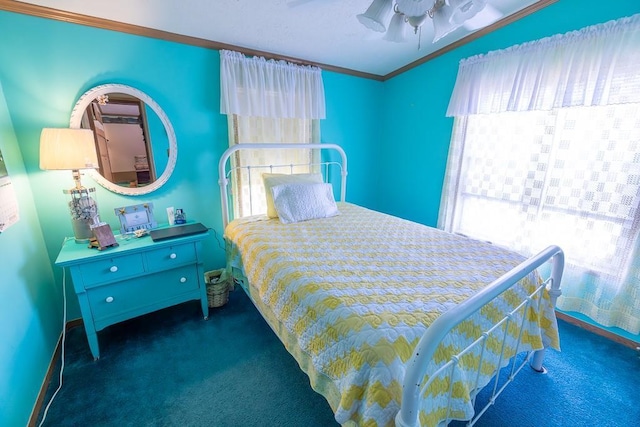 carpeted bedroom featuring baseboards, ornamental molding, ceiling fan, and multiple windows