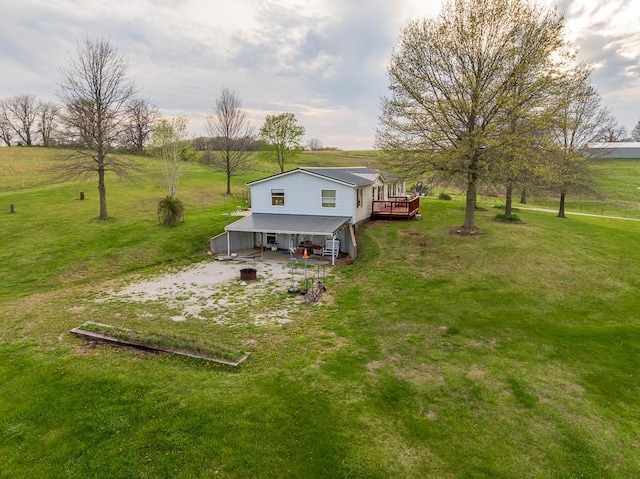 rear view of house with a lawn and a deck