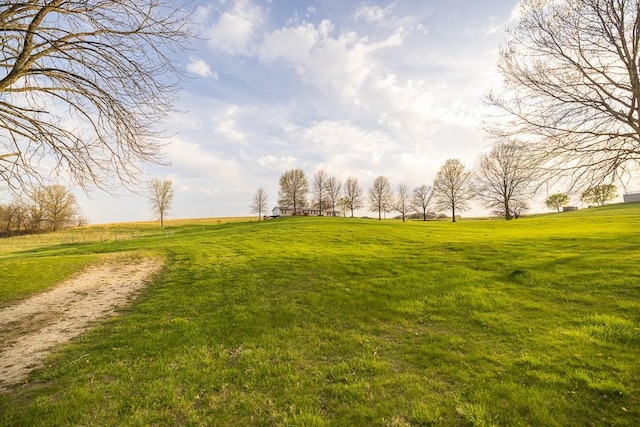 view of community featuring a lawn and a rural view