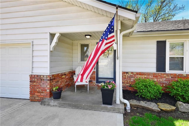 view of exterior entry featuring brick siding, a shingled roof, and a porch