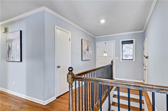 foyer entrance with baseboards, ornamental molding, and wood finished floors