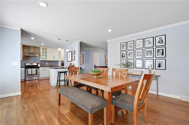 dining area featuring crown molding, baseboards, recessed lighting, and wood finished floors