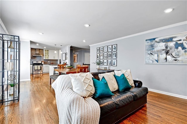 living room with baseboards, ornamental molding, light wood finished floors, and recessed lighting