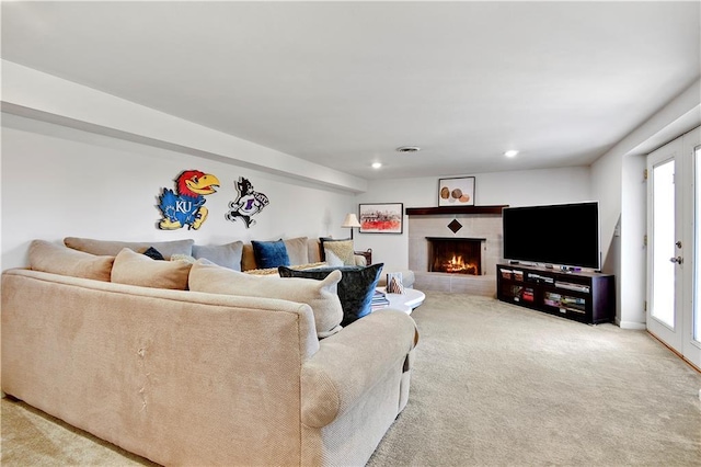 carpeted living room with recessed lighting and a warm lit fireplace