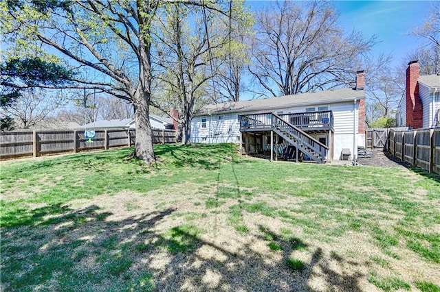 view of yard featuring a deck, stairs, and a fenced backyard