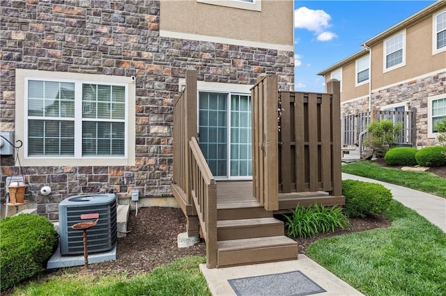 15841 Shawnee Dr, Overland Park, KS 66223 - doorway to property featuring stone siding, central AC, and stucco siding