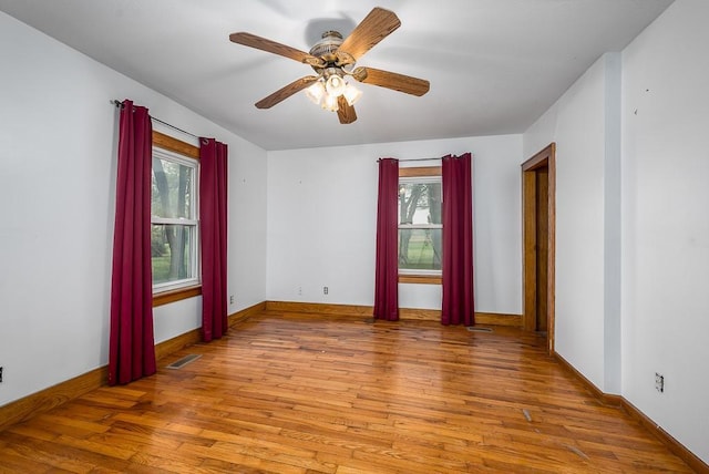 spare room with plenty of natural light and wood finished floors
