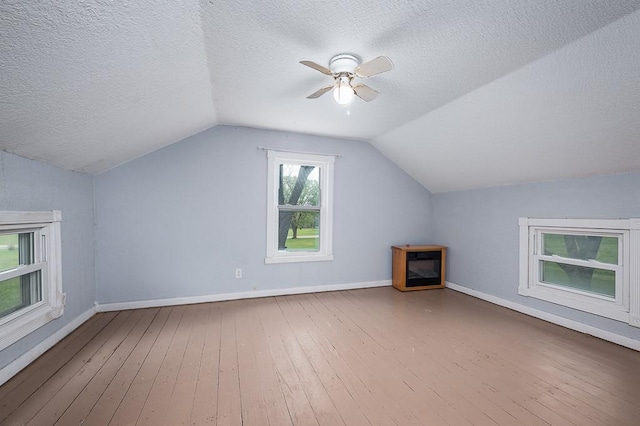 additional living space featuring a textured ceiling, ceiling fan, lofted ceiling, and hardwood / wood-style flooring