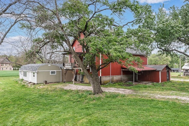 back of property featuring a lawn and an outdoor structure