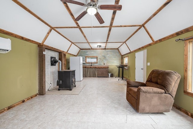 living area with baseboards, a wall mounted AC, and lofted ceiling