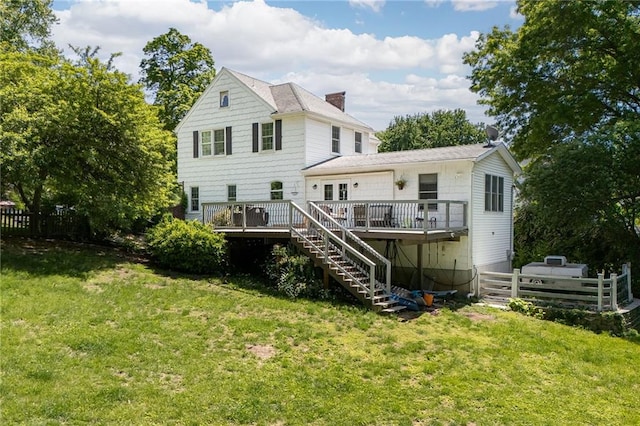 rear view of property with a deck, stairs, and a chimney