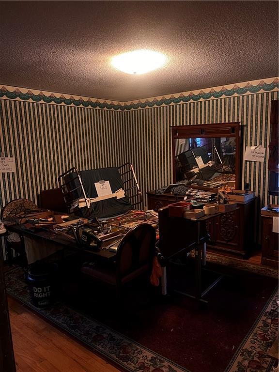 bedroom featuring wood finished floors and wallpapered walls