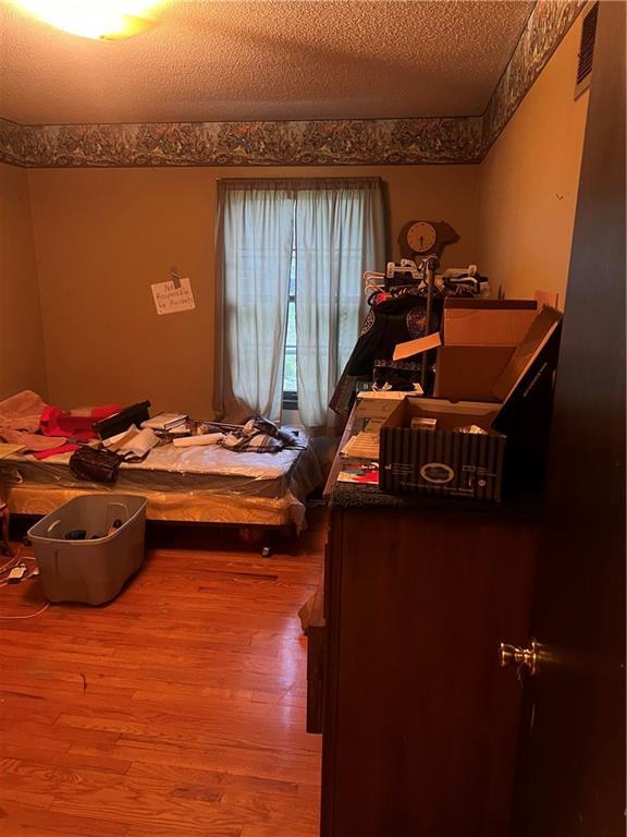 bedroom featuring visible vents and wood finished floors