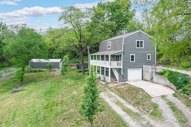rear view of house featuring a porch, dirt driveway, stairway, a gambrel roof, and an attached garage