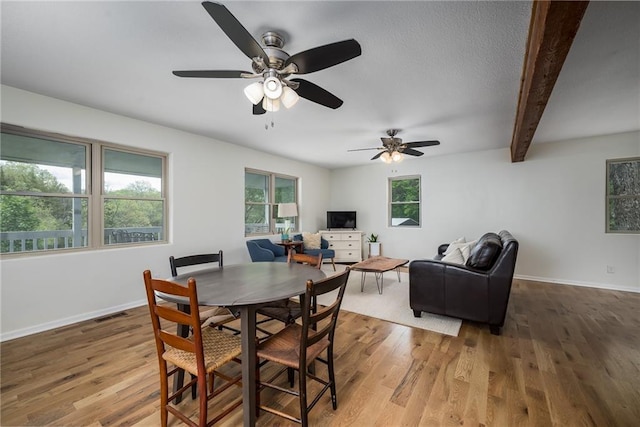 dining room with baseboards, beam ceiling, a ceiling fan, and wood finished floors