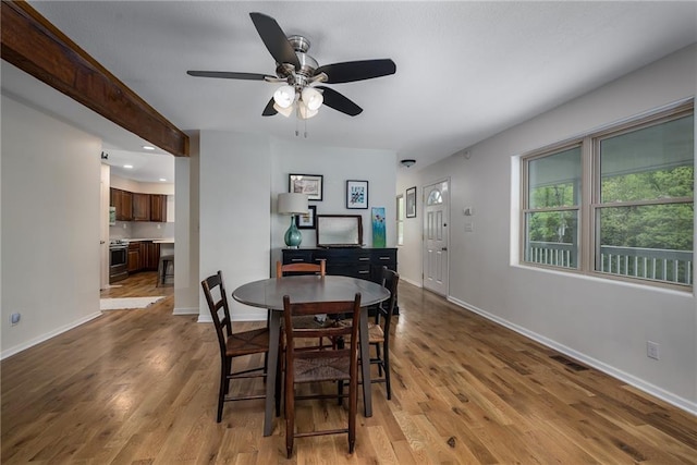 dining room featuring baseboards, ceiling fan, wood finished floors, and visible vents